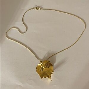 Gold tone metal necklace with leaf pendant